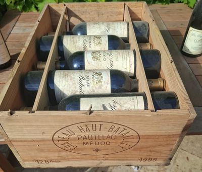 several bottles of wine are in a wooden box on a table