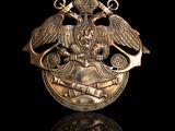 a close up of a gold medal with two birds on it