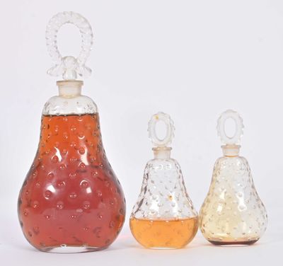 trois bouteilles de liquide posées les unes à côté des autres sur une surface blanche