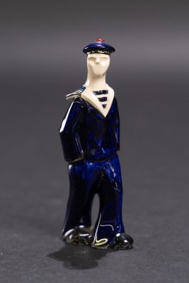 une petite figurine représentant un homme portant un chapeau et une cravate