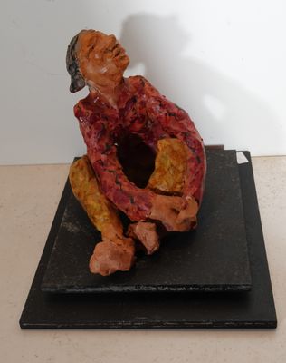 statue of a man sitting on a black base with a white background