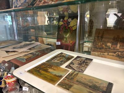 une vitrine remplie de tableaux et de vases