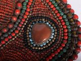 a close up of a beaded bracelet with a stone in the center
