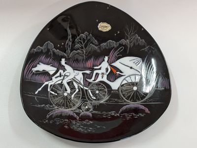 a black plate with a picture of a horse drawn carriage