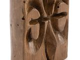 carved wooden block with four faces on it on a white background
