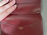 a person holding a wallet that is open on a table