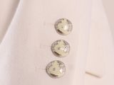 a close up of three buttons on a white jacket