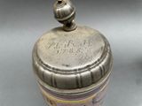 a silver container with a lid that has a picture on it