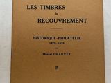 un vieux livre posé sur une table, sur laquelle se trouve une horloge
