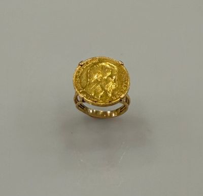 Gros plan sur une bague en or ornée d'une pièce de monnaie