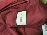 a label on a red jacket that says gucci