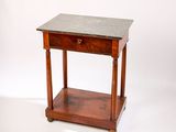 une petite table en bois avec un plateau en marbre, montée sur roulettes