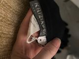 the hand is holding a black purse with a label on it