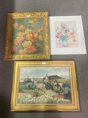 trois tableaux encadrés posés sur une table, avec un vase de fleurs et un autre vase de fleurs