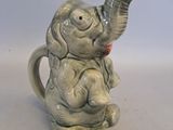 un éléphant qui tient une tasse dans sa trompe