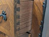 a close up of a wooden dresser with a metal handle
