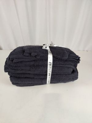 une pile de serviettes noires pliées posée sur une table blanche