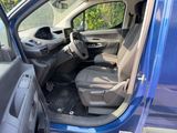 the interior of a blue van with the door open and the driver ' s seat down