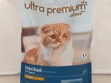 an orange and white cat sitting on top of a bag of cat food