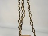 an orange glass bowl with a gold chain hanging from it ' s sides