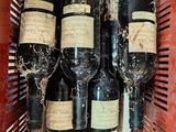 several bottles of wine are in a red basket on a table