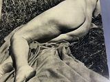 an old black and white photo of a naked woman laying on a blanket