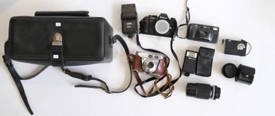 tout un tas d'appareils photo et d'accessoires de toutes sortes disposés sur la table