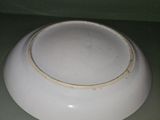 a white bowl sitting on top of a green shelf