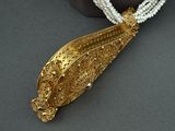 a necklace with a gold leaf and pearls on it