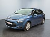 La Citroën bleue est garée dans une pièce au sol noir.