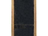 un miroir ancien dans un cadre doré, avec un fond noir et des bordures dorées