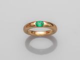 a gold ring with an emerald stone in the center