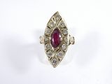 a close up of a ring with a ruby stone surrounded by diamonds