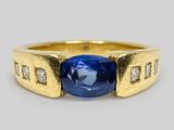 un gros plan sur une bague sertie d'un saphir bleu et de diamants