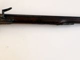 un vieux fusil accroché au mur d'une pièce