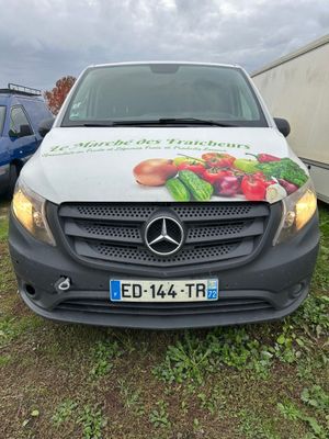 a white van parked in front of a trailer with a sign on it
