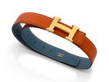 une ceinture Hermès avec une boucle dorée sur fond blanc