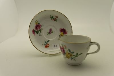 une tasse et une soucoupe posées sur une table blanche