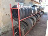many tires stacked on a red rack in a garage