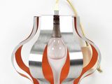 an orange and silver lamp hanging from a wall on a white background