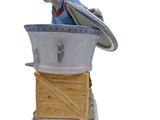 a figurine of a boy sitting on top of a box
