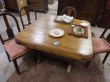 une table en bois avec quatre chaises et une assiette posée dessus