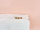 une bague en or posée sur un bloc de marbre