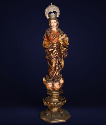 une statue représentant cette personne tenant un enfant dans ses bras, posée sur un socle