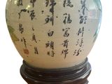 a white vase with asian writing on it on a stand