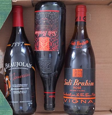 trois bouteilles de vin dans un coffret sur une table