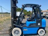 un chariot élévateur bleu garé sur un parking