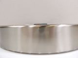 a silver bowl on a white surface with a red dot