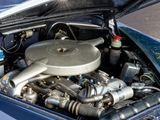 a blue car with an engine in the trunk of it