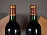 two bottles of wine sitting next to each other on a table